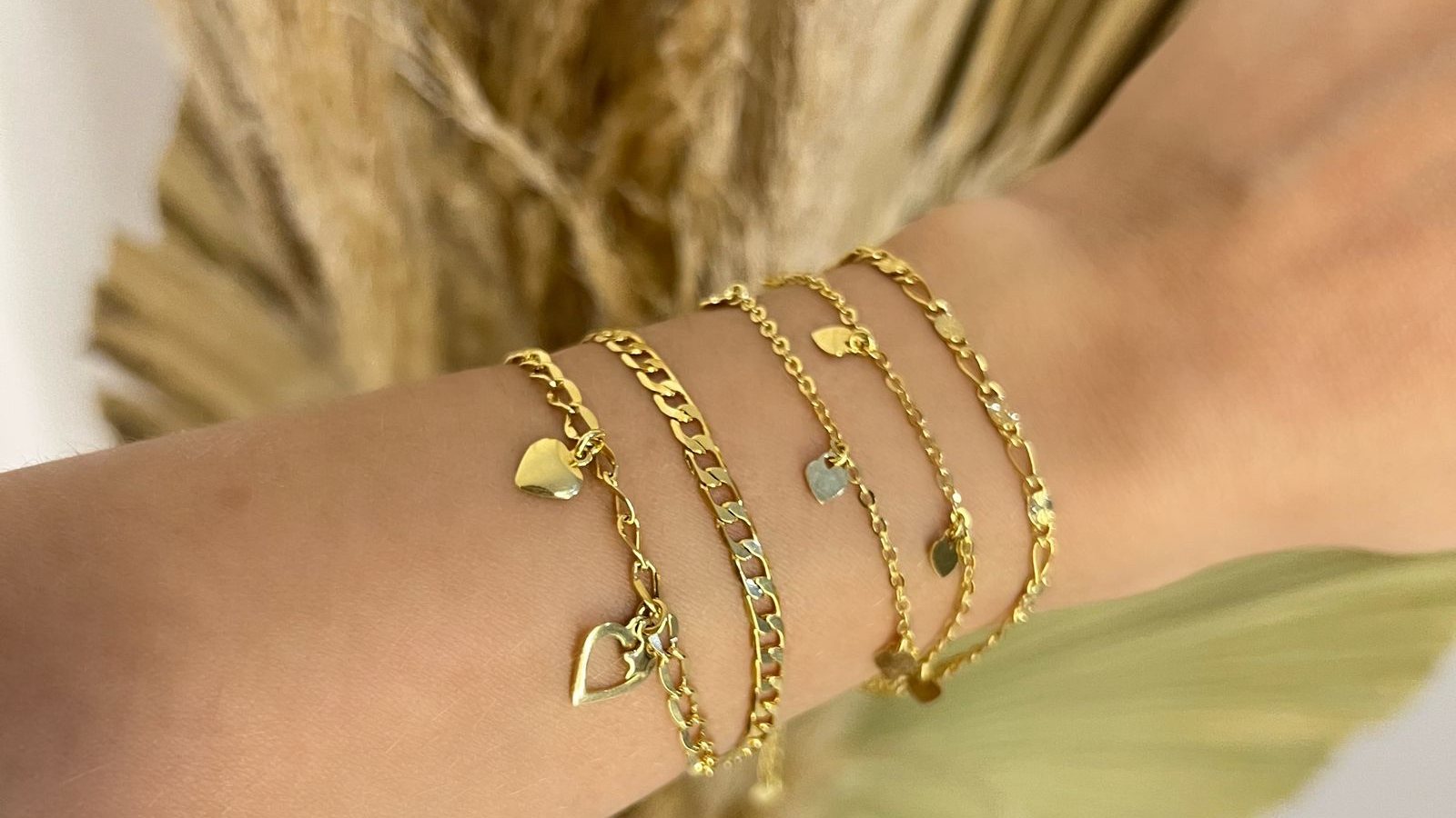 Pulseiras douradas com pingentes de coração